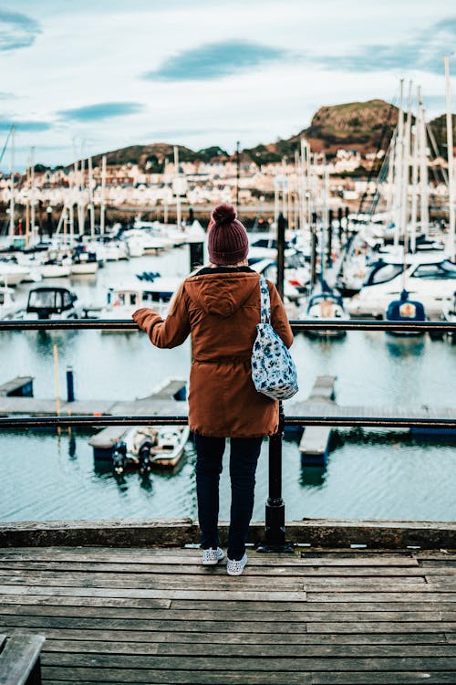 Free Person in Brown Hoodie Jacket Standing on Dock Stock Photo