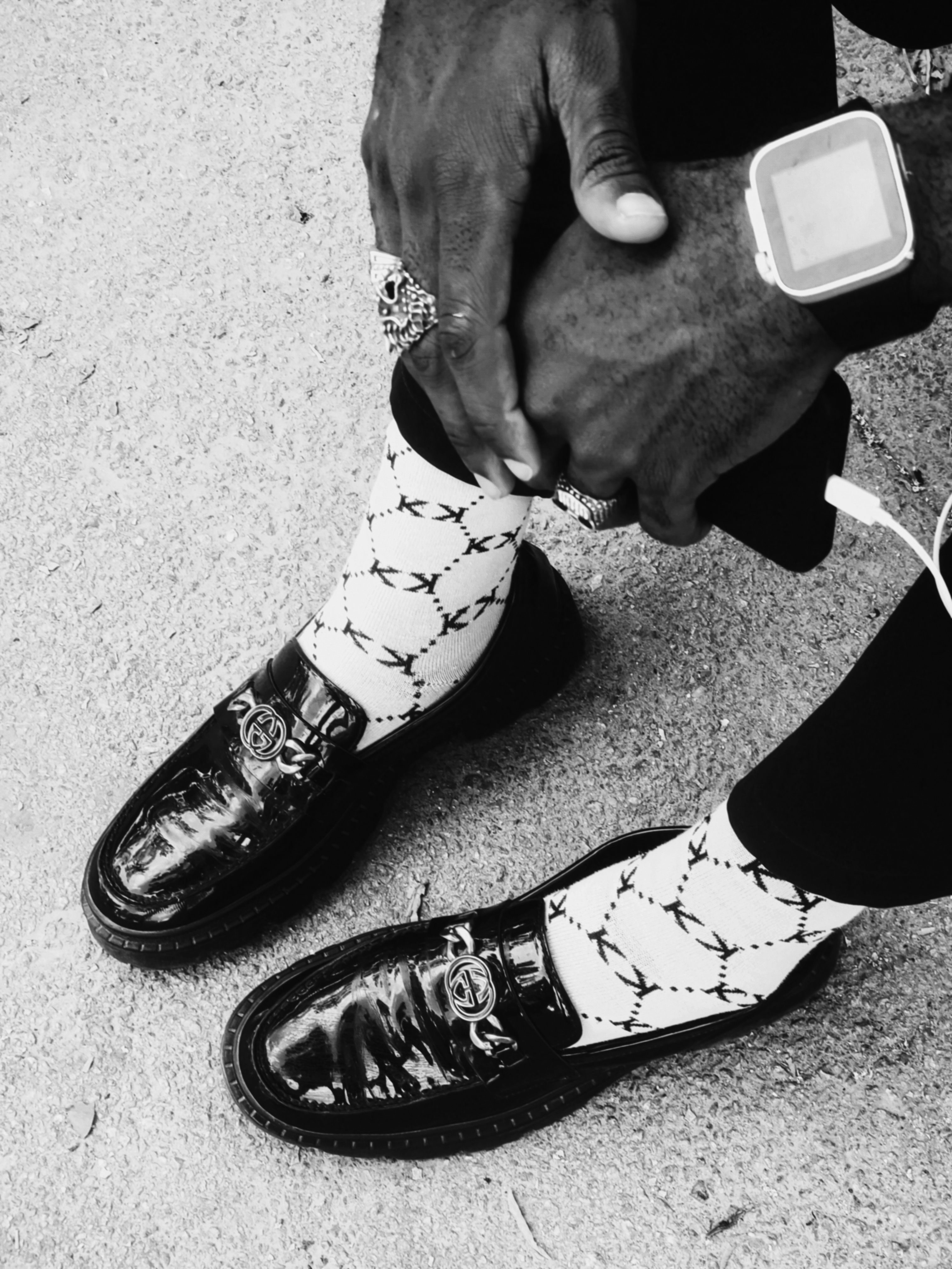 Close-up of a fashionable outfit with unique socks and polished shoes.