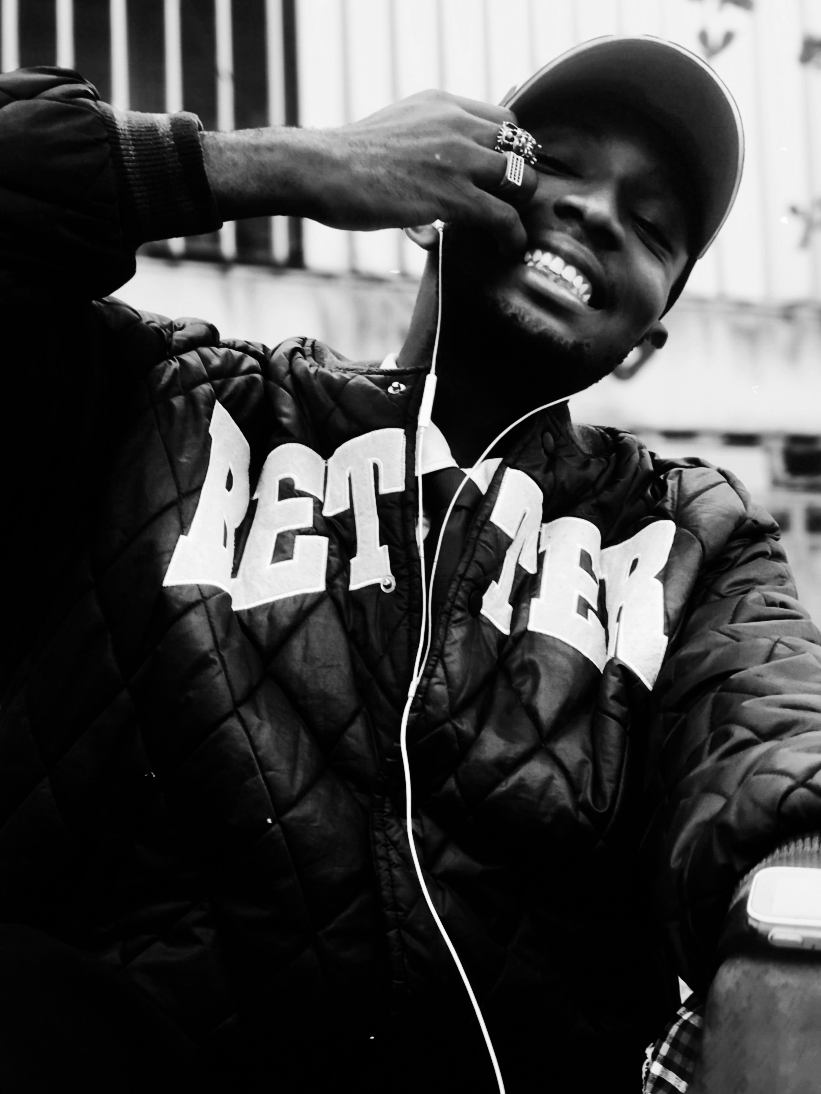 A trendy urban black and white portrait of a young man with headphones, wearing a stylish jacket.