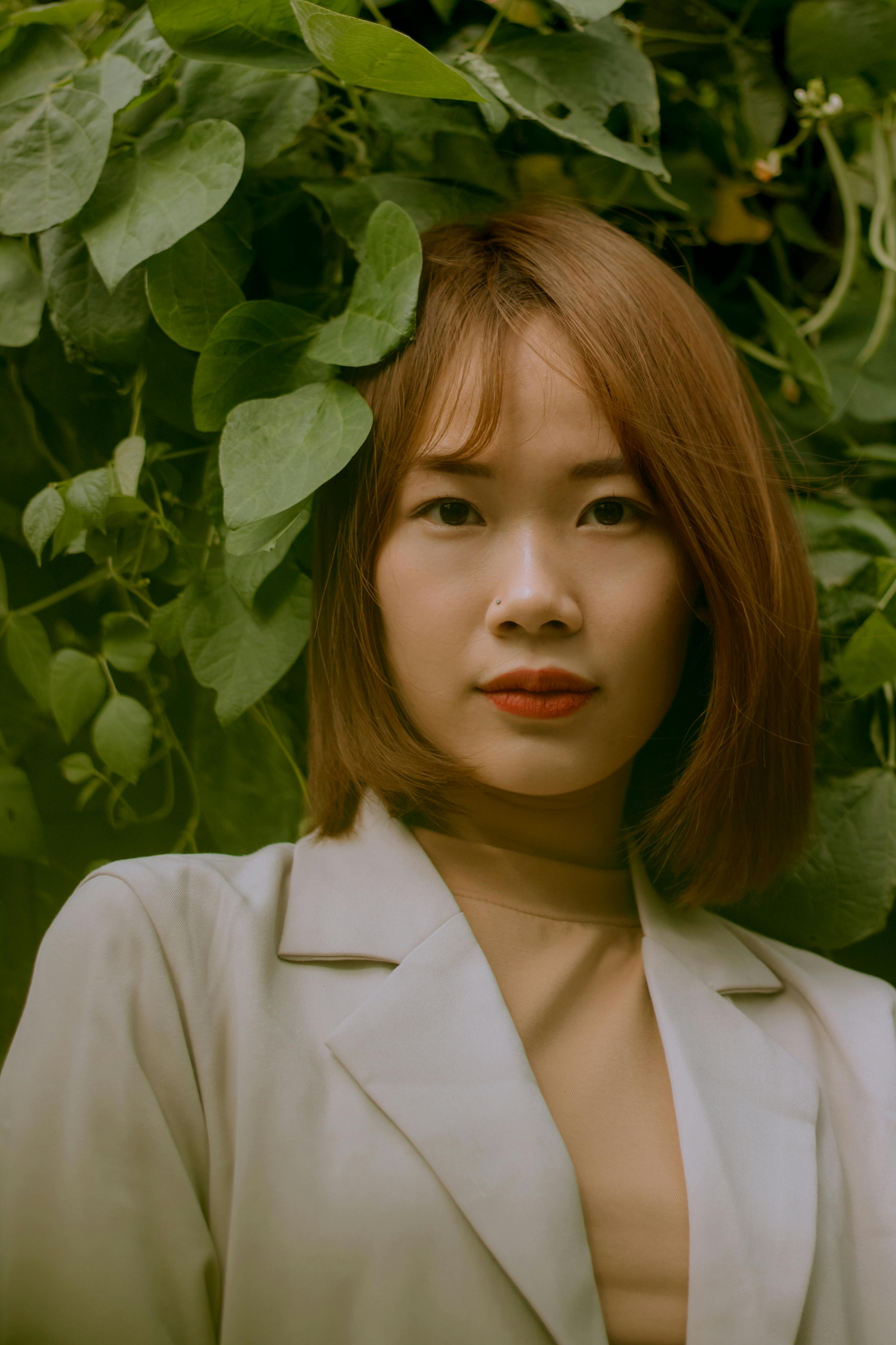 在中国青海，一位亚洲妇女的优雅肖像被郁郁葱葱的绿叶环绕