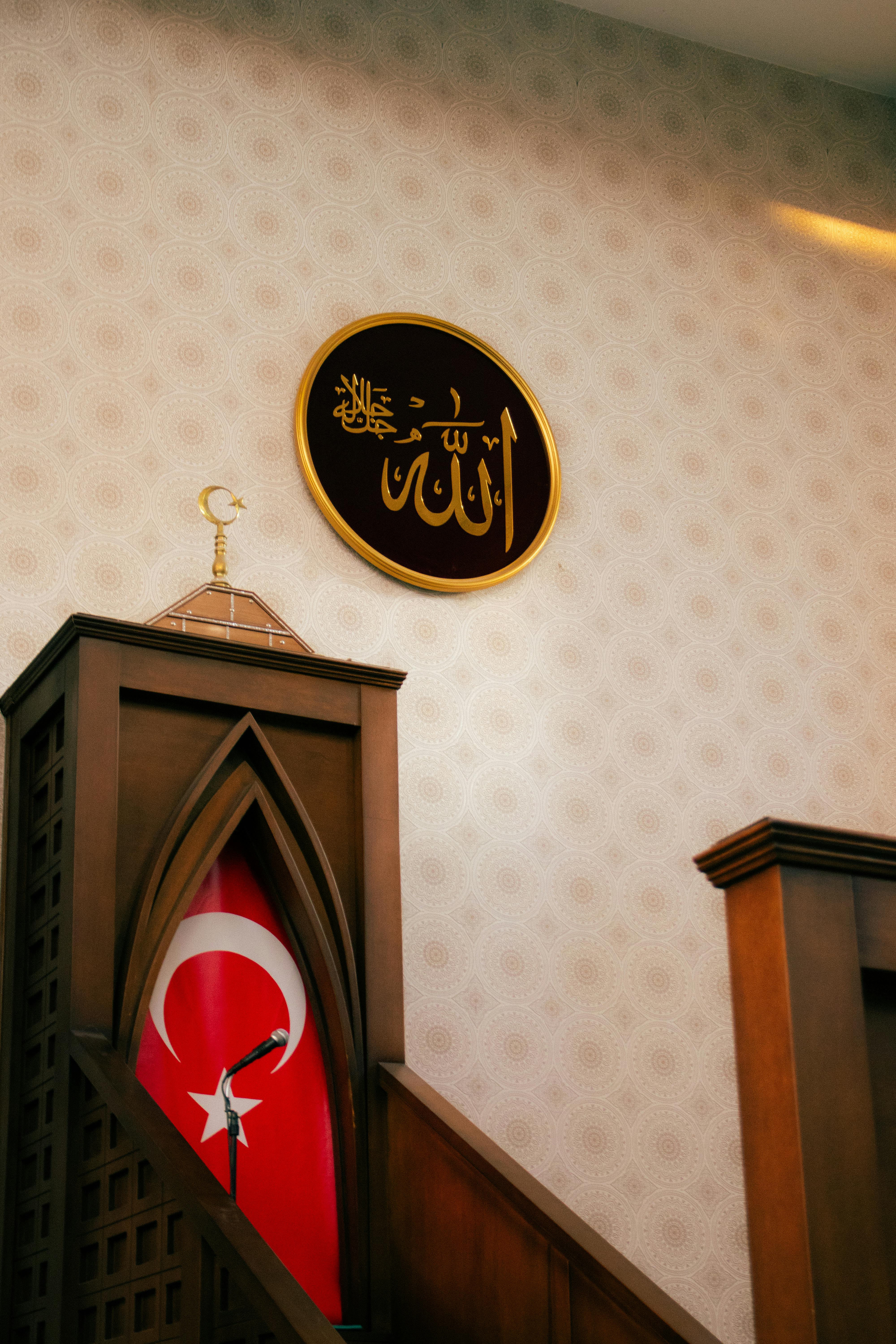 A mosque interior featuring a Turkish flag and Arabic calligraphy, evoking cultural and religious themes.