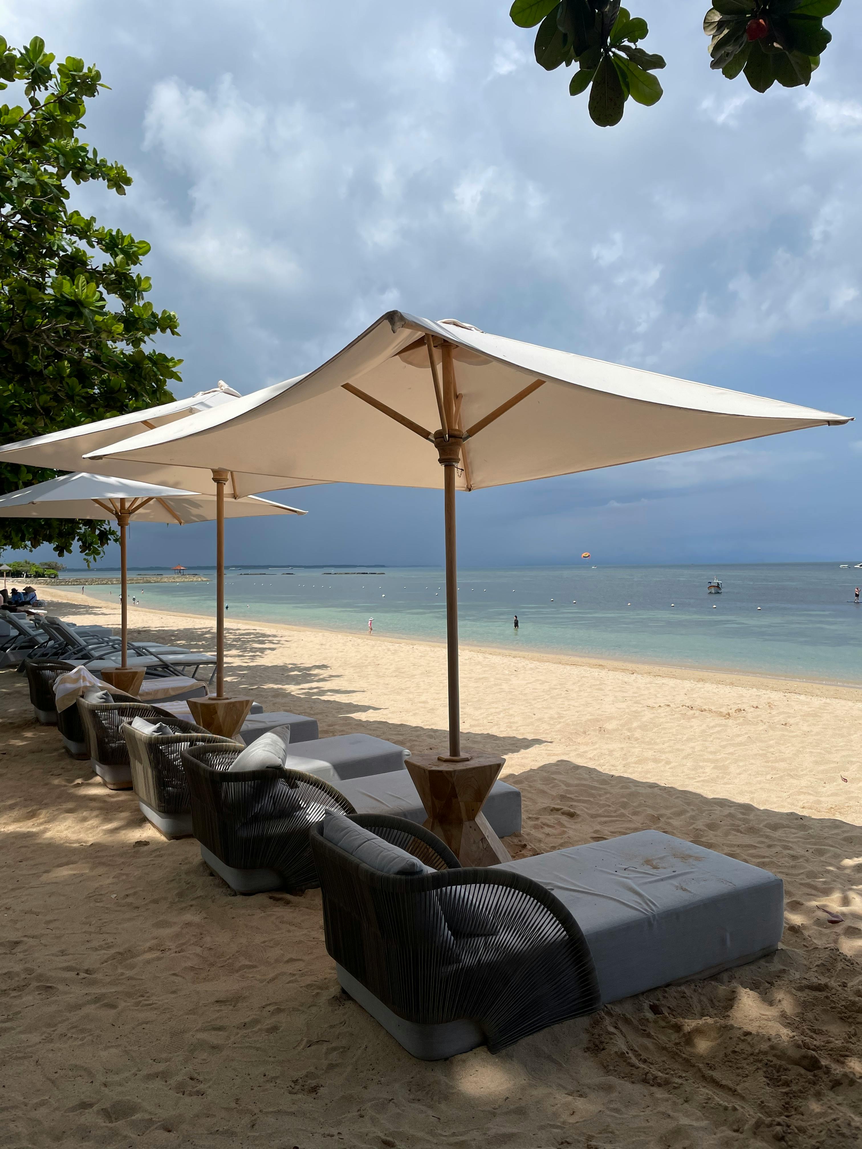 Sun loungers and bean bags facing the Indian Ocean at sunset on Seminyak Beach in Bali