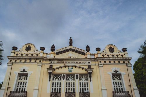 Free Front view of the historic Alberto Maranhão Theatre in Natal, Brazil, showcasing neoclassical architecture under a blue sky. Stock Photo