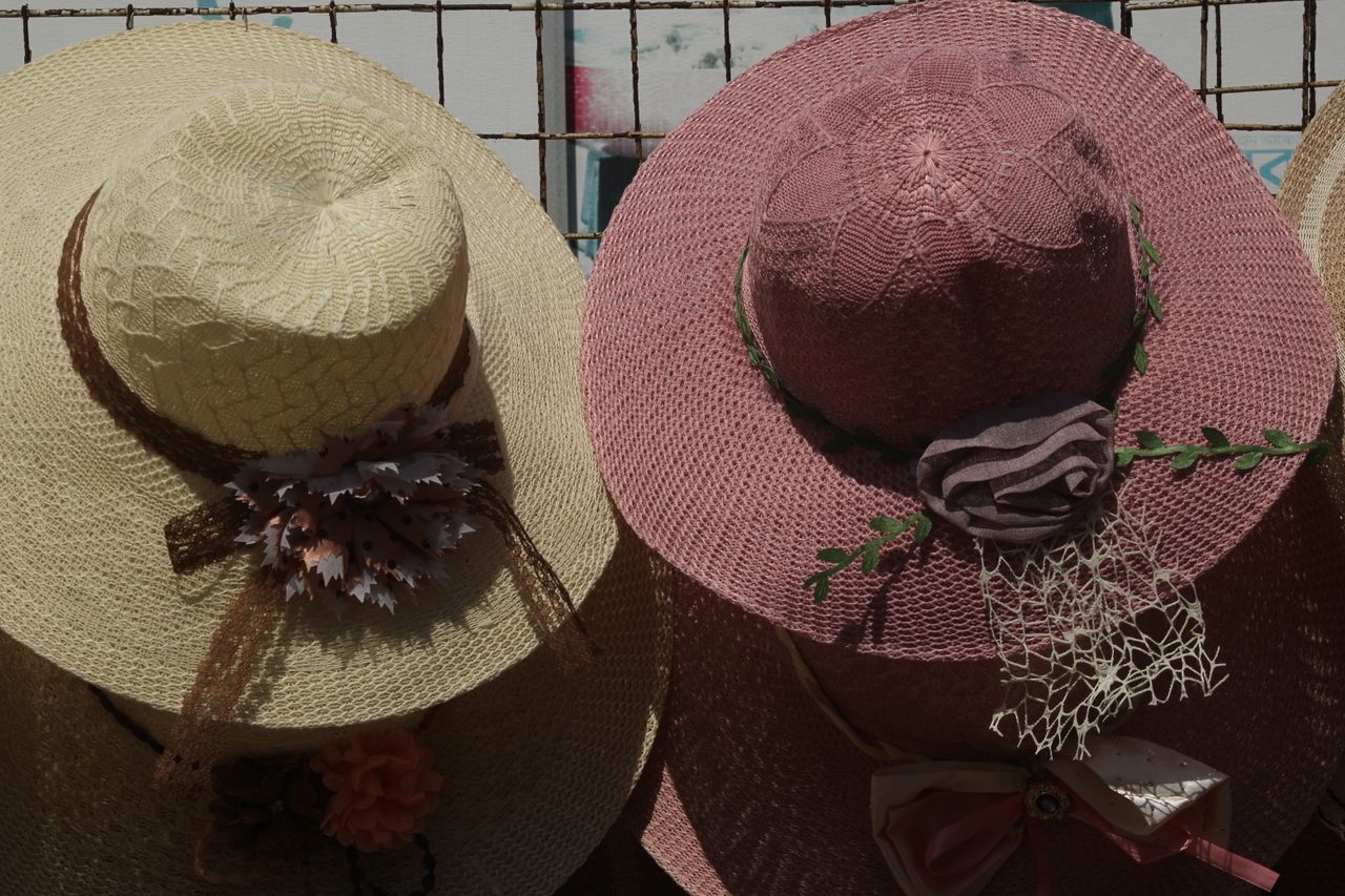 a collection of stylish straw hats with decorative flowers displayed o