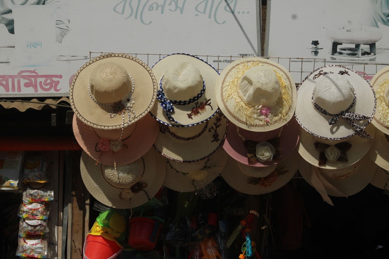 a collection of decorative straw hats displayed in an outdoor market s