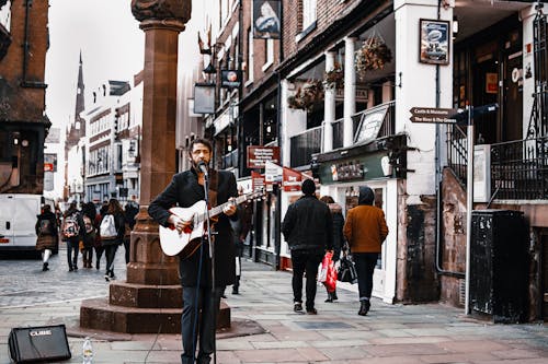 Free Man Standing on Street Playing Guitar Stock Photo
