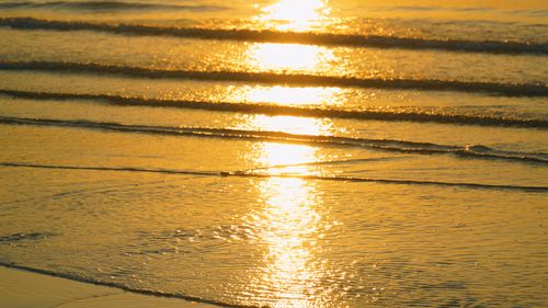 Free Sunrise reflecting off ocean waves, creating a tranquil and golden seascape. Stock Photo