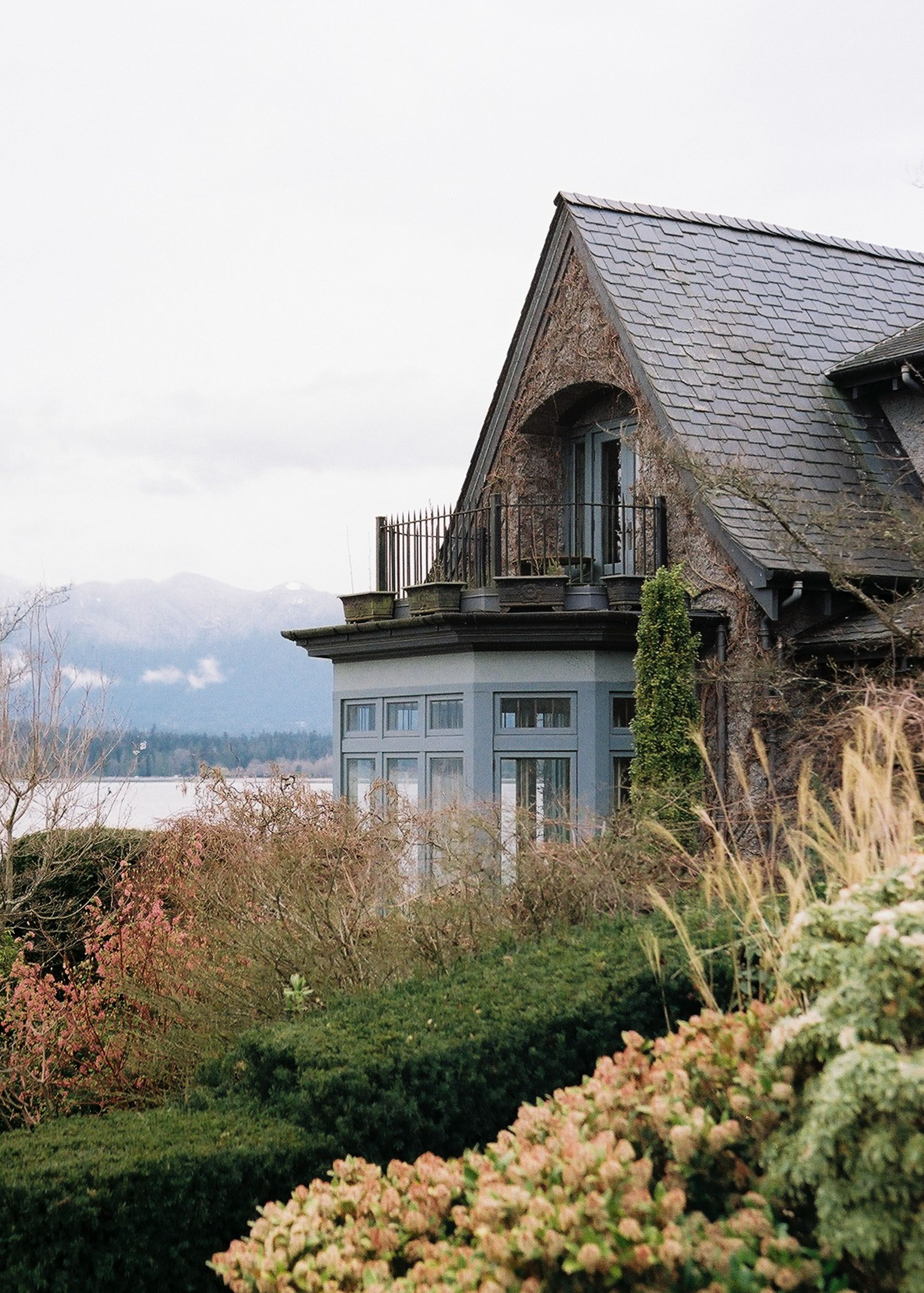 Elegant lakeside house in Vancouver with lush greenery and a serene coastal view.