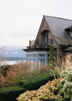 Elegant lakeside house in Vancouver with lush greenery and a serene coastal view.