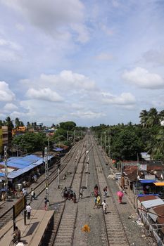 A vibrant aerial view of bustling railway tracks filled with people in Kolkata, India.