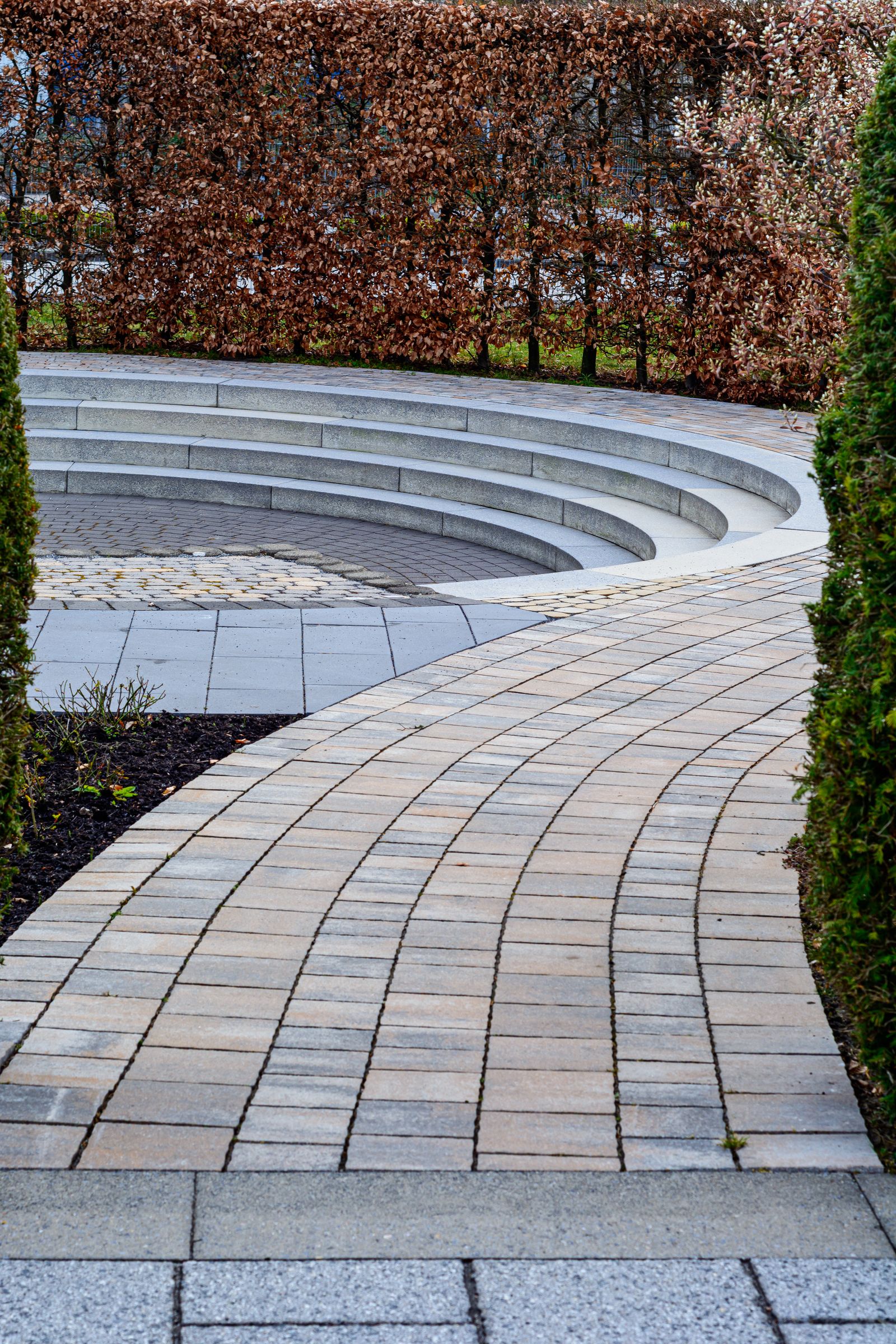 Gepflasterter Gartenweg zu einem modernen, abgesenkten Sitzbereich