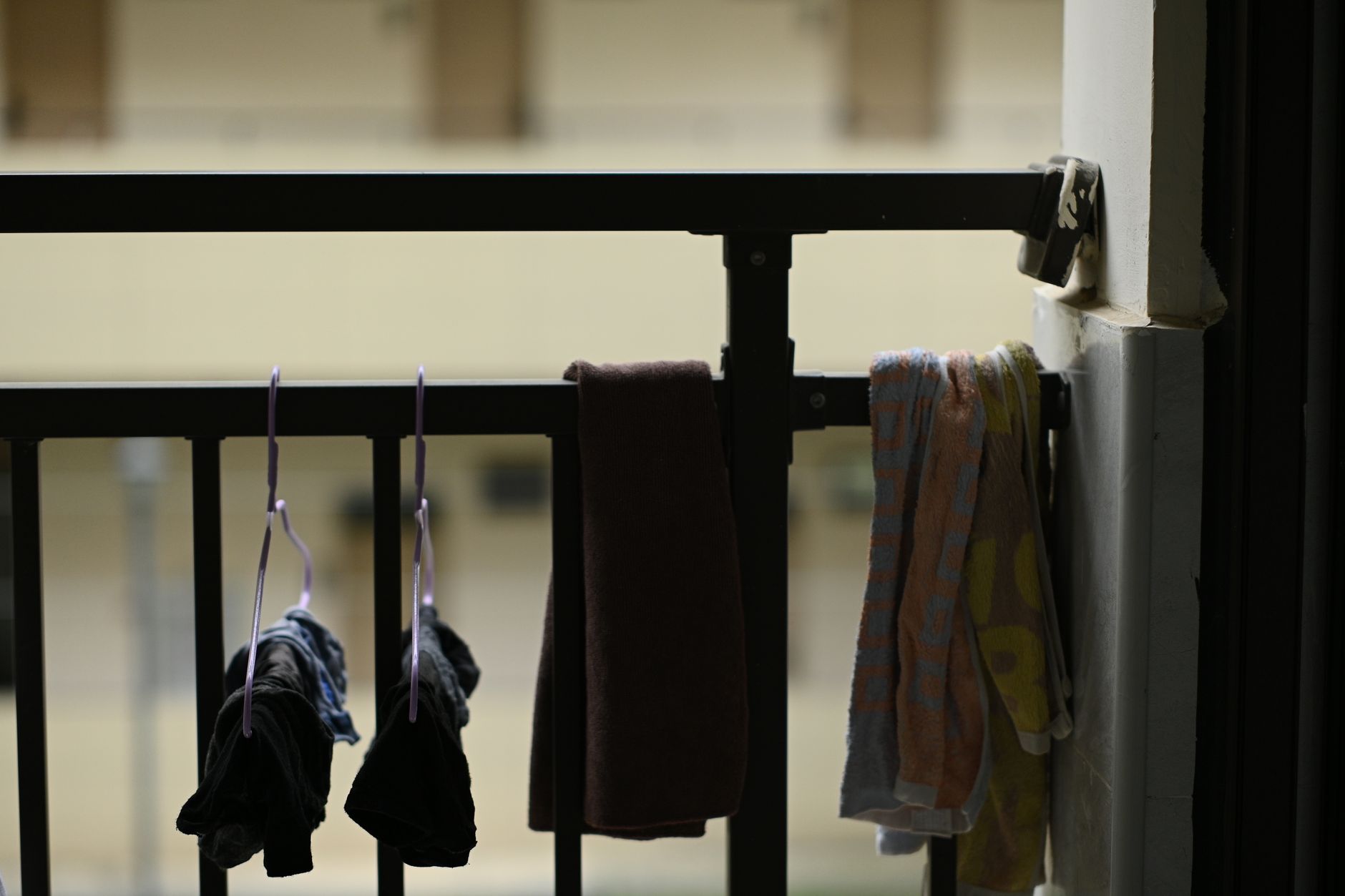 Clothes and towels hung for drying on an indoor balcony rail, creating a homey atmosphere.