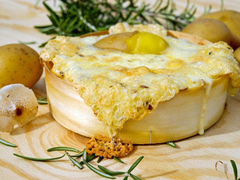 Fromage à raclette fondu doré avec pommes de terre