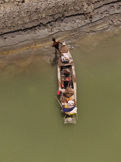 Free Aerial view of fishermen on a narrow boat in the Punjab river region, showcasing local life. Stock Photo