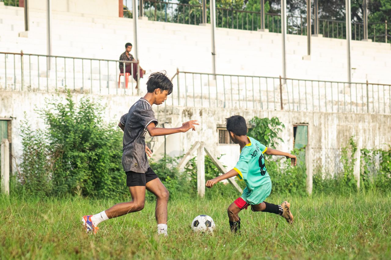 boys playing soccer on a field in myawaddy myanmar showcasing action a