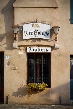 Charming facade of Trattoria Tre Corone in Grado, Italy, featuring vintage decor and signage.