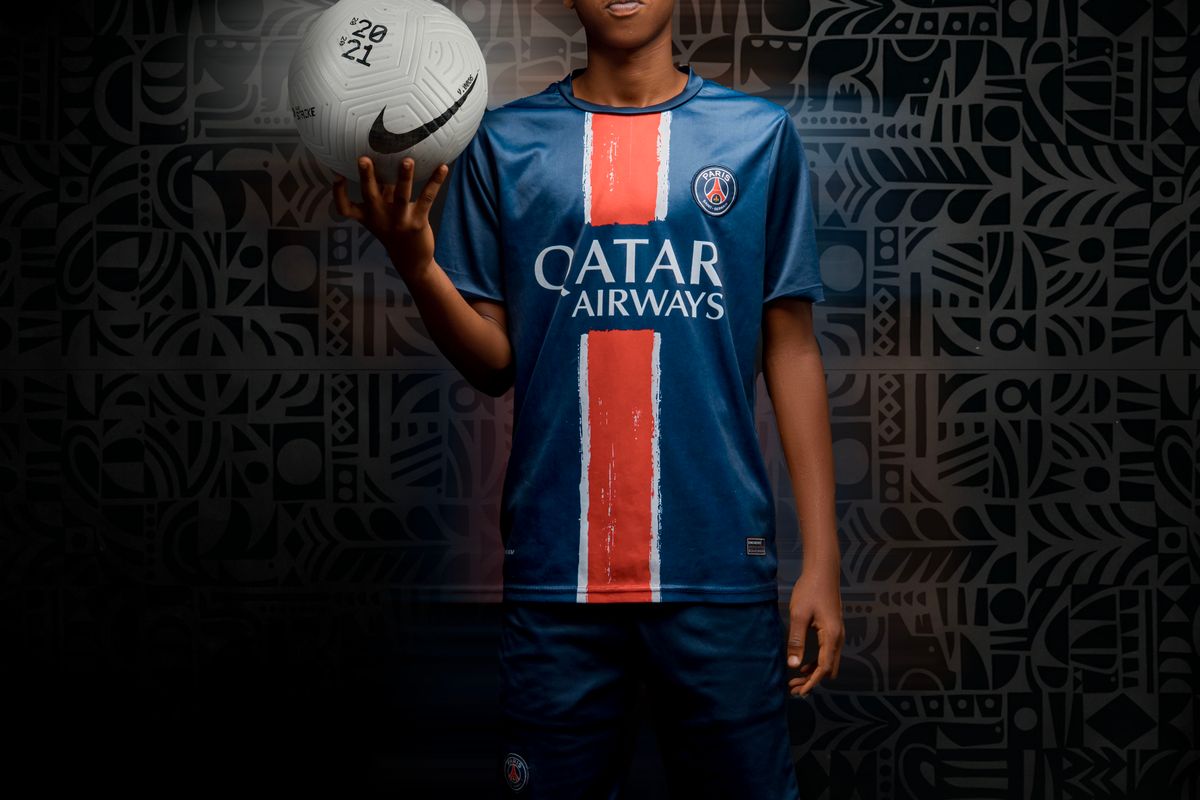Athlete holding a football in a studio portrait