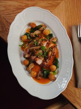Delicious gourmet chicken dish served with mushrooms, greens, and sauce on an elegant plate.