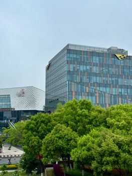 Contemporary architecture with glass facades amidst vibrant greenery in Shanghai.
