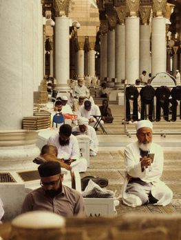 People seated and reading in the serene atmosphere of Al-Masjid an-Nabawi, Medina.