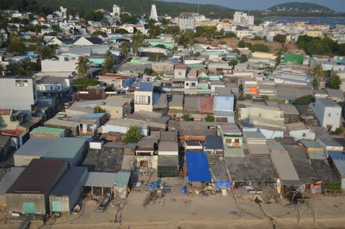 Free Aerial shot showcasing a densely packed coastal residential area with diverse rooftops. Stock Photo