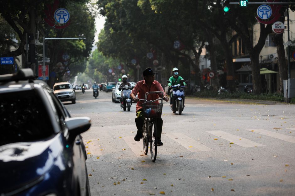 Grab motorbike taxi navigating busy streets in Hanoi, Vietnam