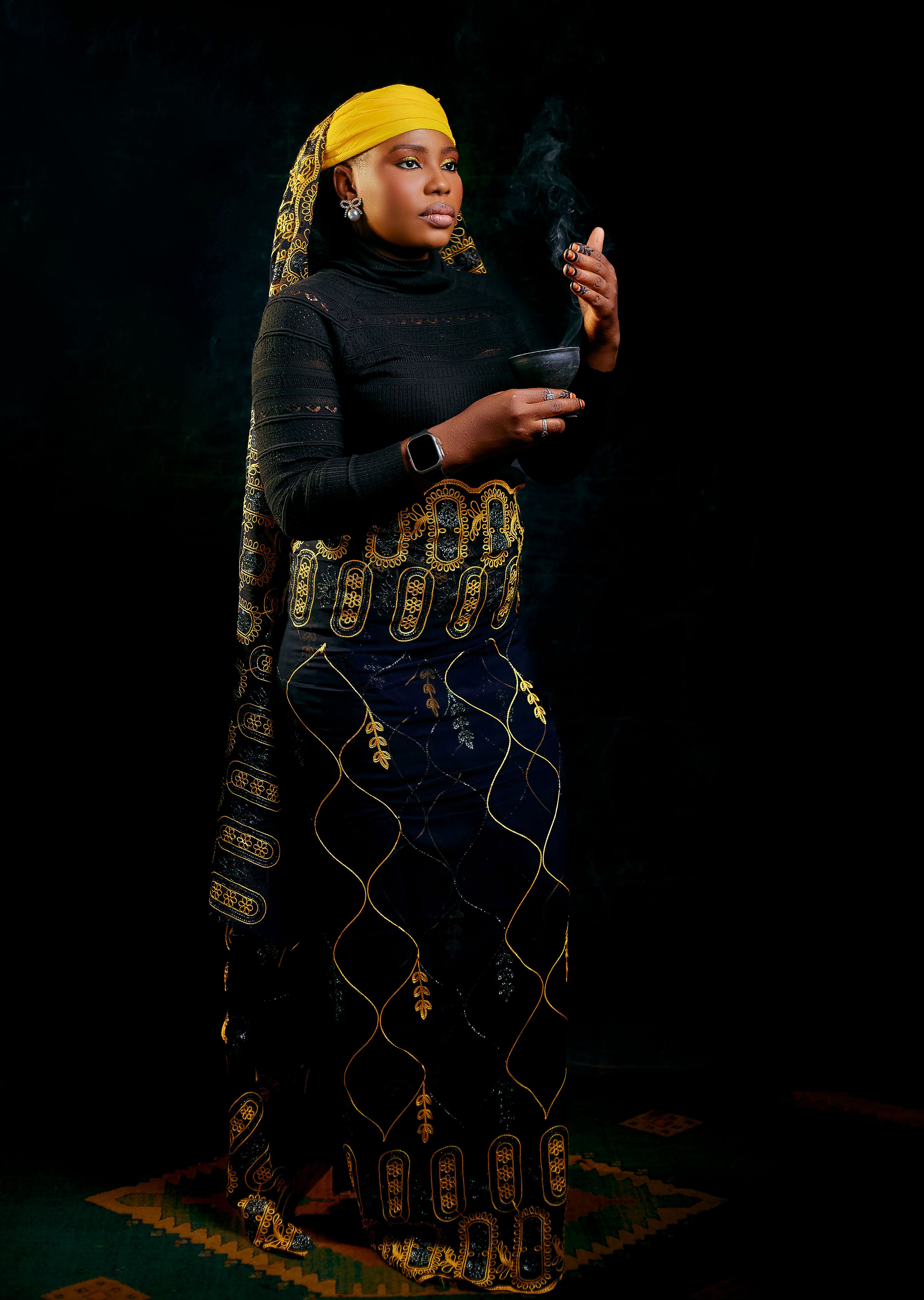 Woman in vibrant African attire holding incense, capturing cultural essence.