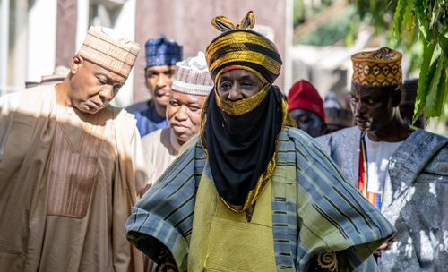 Free A group of men in traditional African attire participating in a cultural ceremony outdoors. Stock Photo