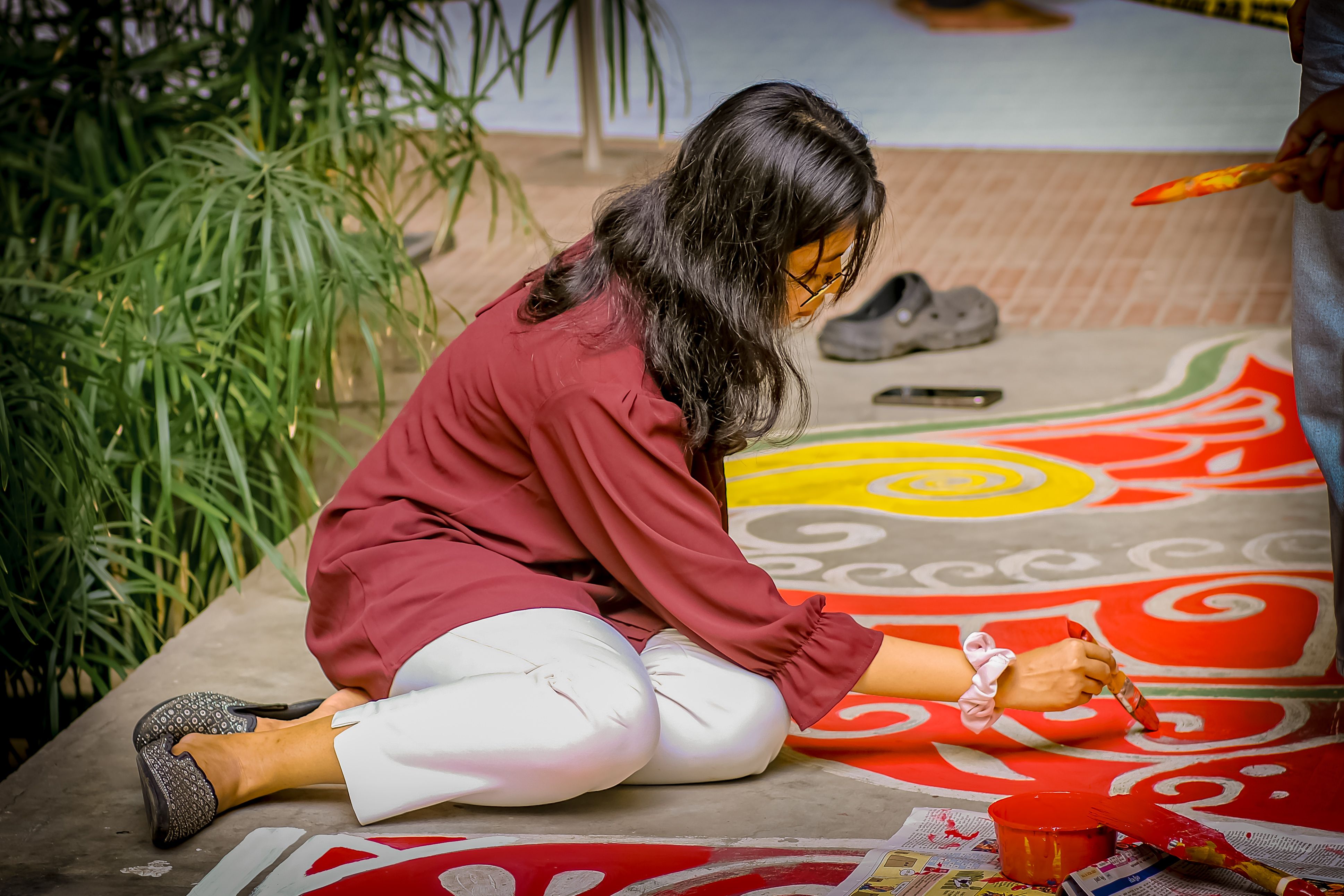 Woman creating colorful rangoli art outdoors · Free Stock Photo