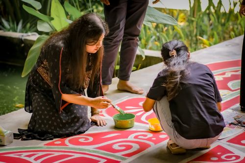 Free Two women crafting intricate Rangoli design with vibrant colors outdoors. Stock Photo
