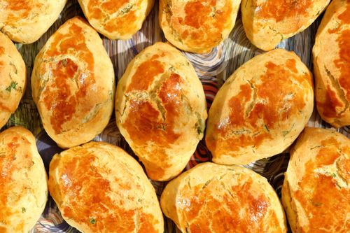 Free A collection of freshly baked golden brown bread rolls with a shiny crust on a patterned surface. Stock Photo