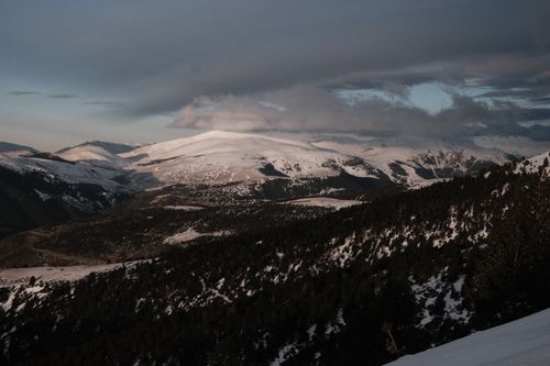 Free Serene view of snow-covered mountains with dramatic sky during dusk, perfect for nature and travel enthusiasts. Stock Photo