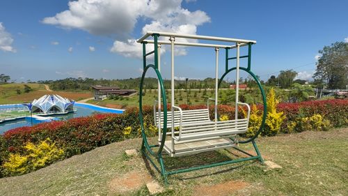 Free Vibrant park setting featuring a swing, modern pavilion, and lush landscape under a bright blue sky. Stock Photo