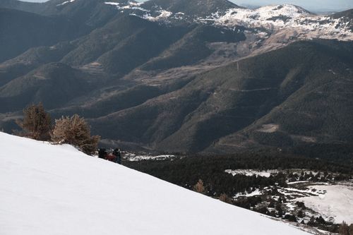 Free Adventurous group hiking on snowy alpine slopes with scenic mountain views. Stock Photo