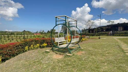 Free Circular garden bench set against vibrant green landscape under a bright blue sky, creating a serene atmosphere. Stock Photo