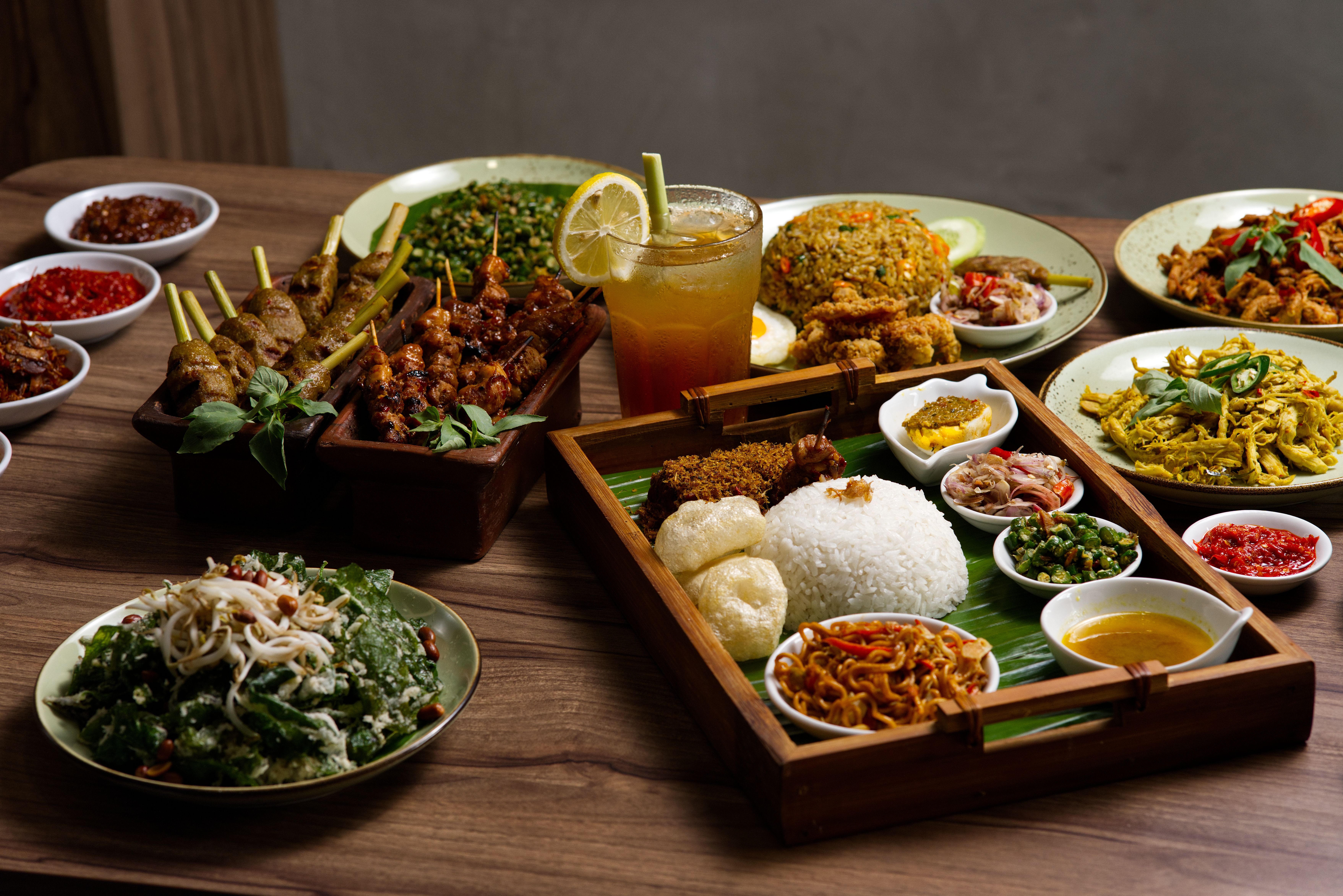 A vibrant spread of traditional Indonesian dishes including satay and nasi campur.
