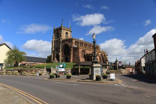Free A historic stone church under a bright blue sky in a charming small town setting. Stock Photo