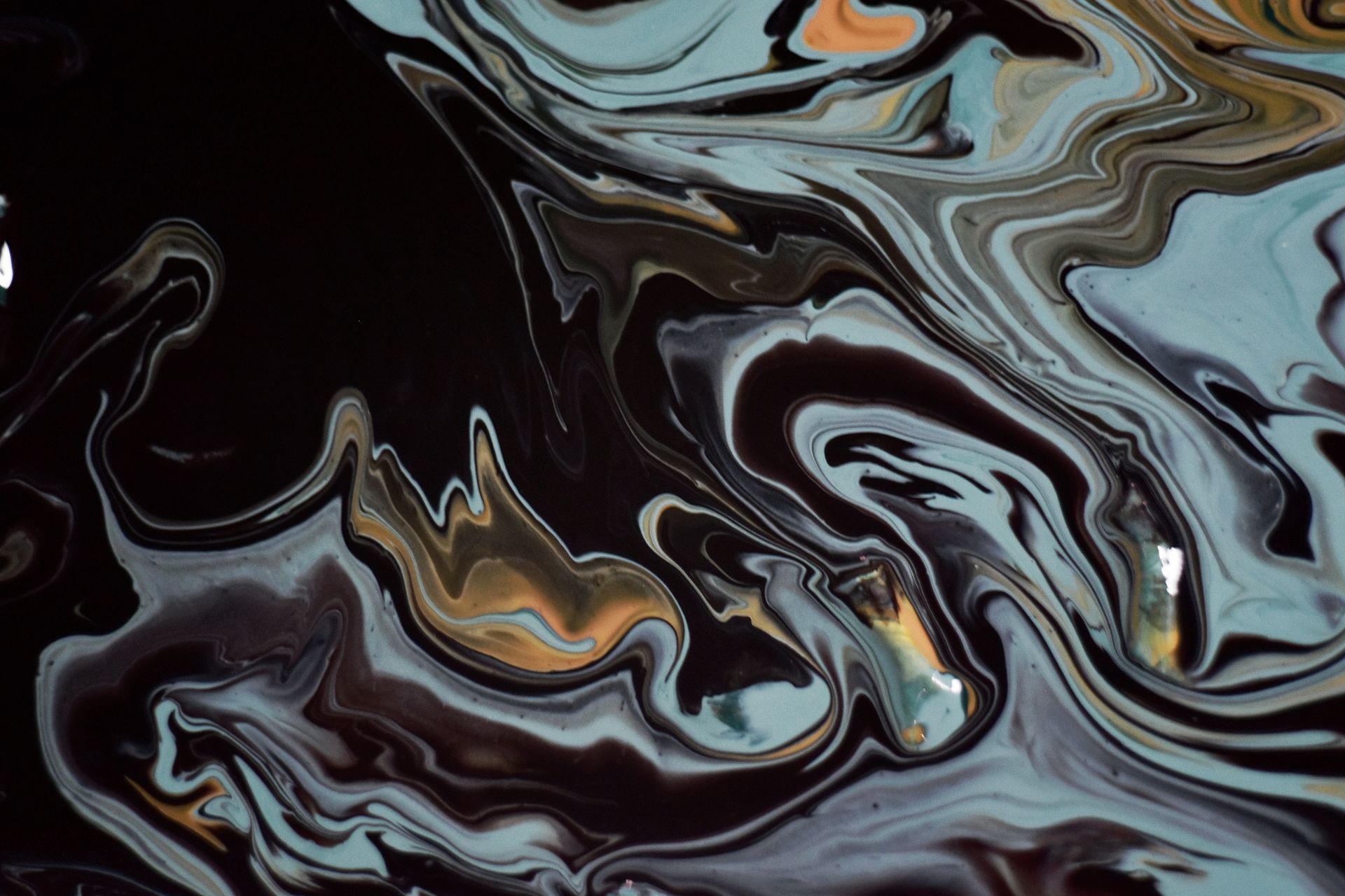 Vibrant abstract acrylic paint flow creating dynamic swirls in warm tones.