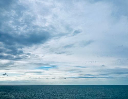 Free Serene ocean view with a vast cloudy sky, capturing a peaceful moment at sea. Stock Photo