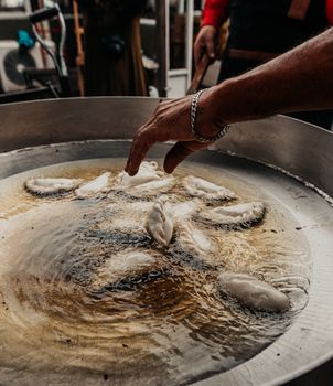 Crispy empanadas frying in oil at an Argentine street market in Buenos Aires.