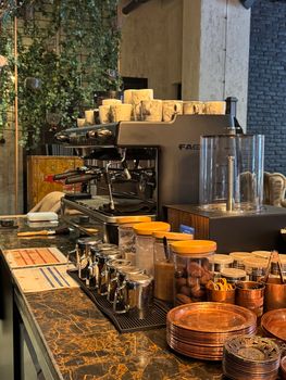 Warm cafe interior featuring an espresso machine and assorted supplies, creating a welcoming vibe.