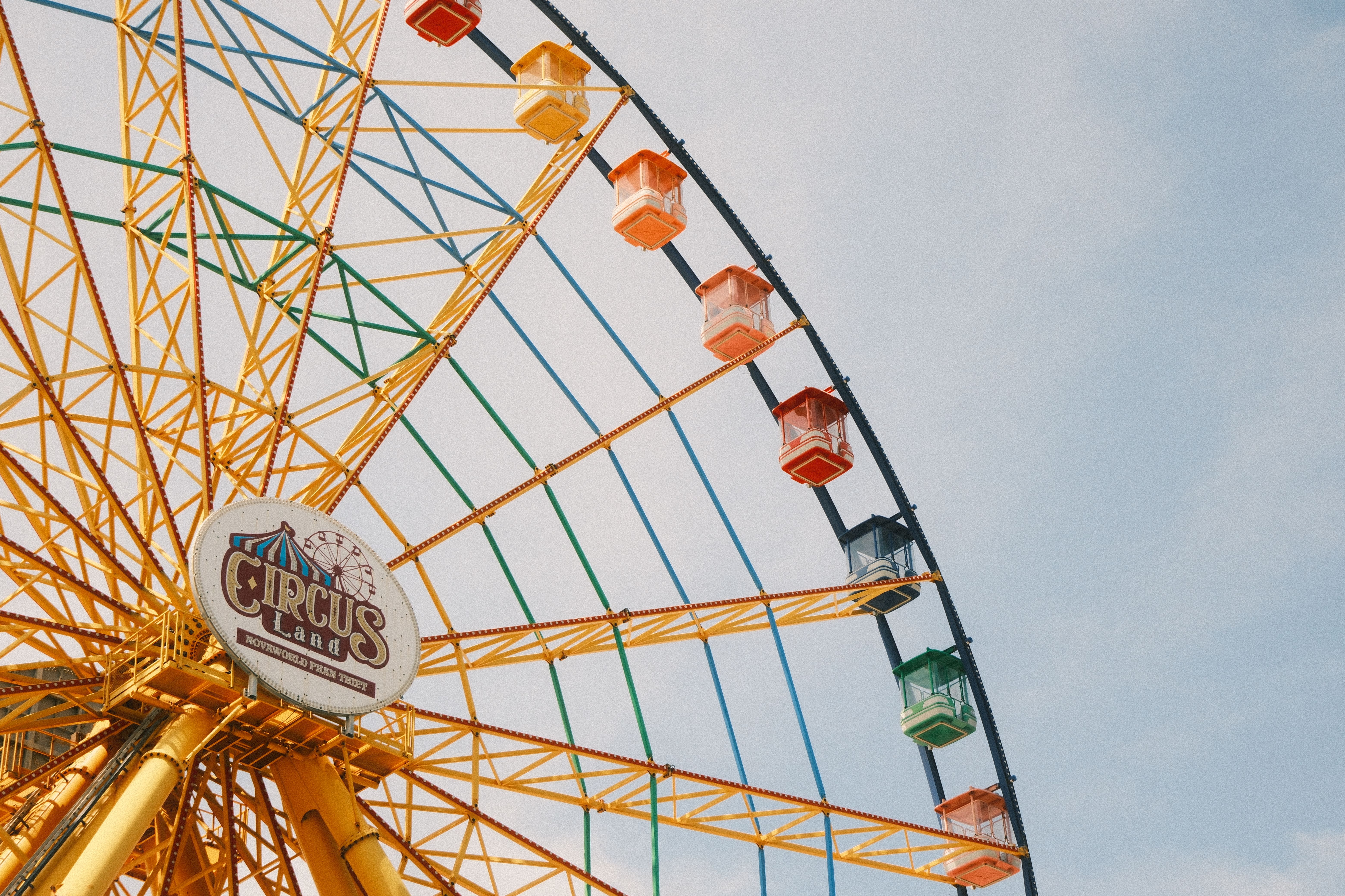 Close-up of colorful Ferris wheel at Circus Land in Vietnam under a bright sky.