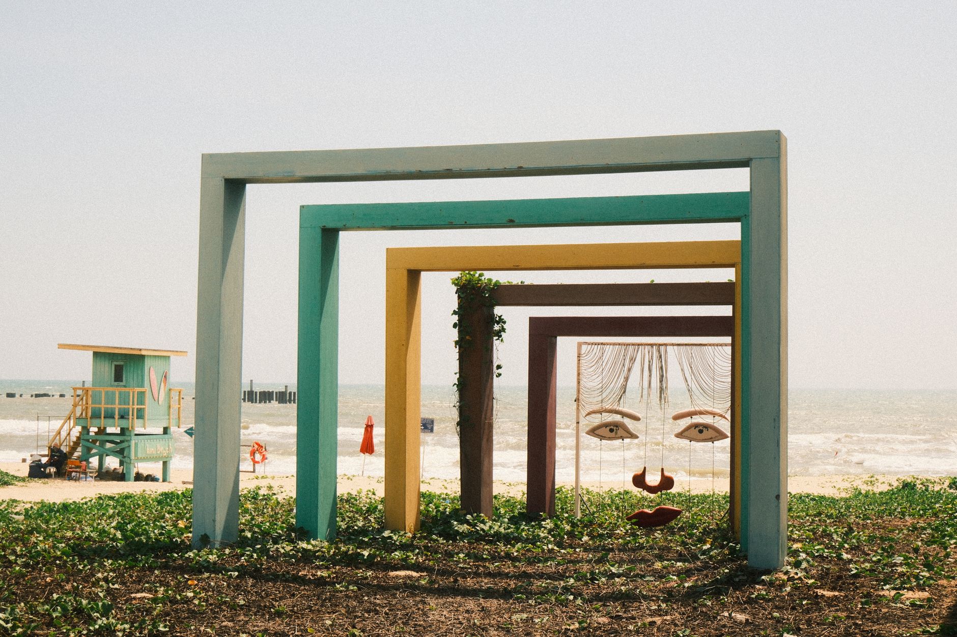 Colorful geometric frames on a beach in Phan Thiet, Vietnam, with ocean backdrop.