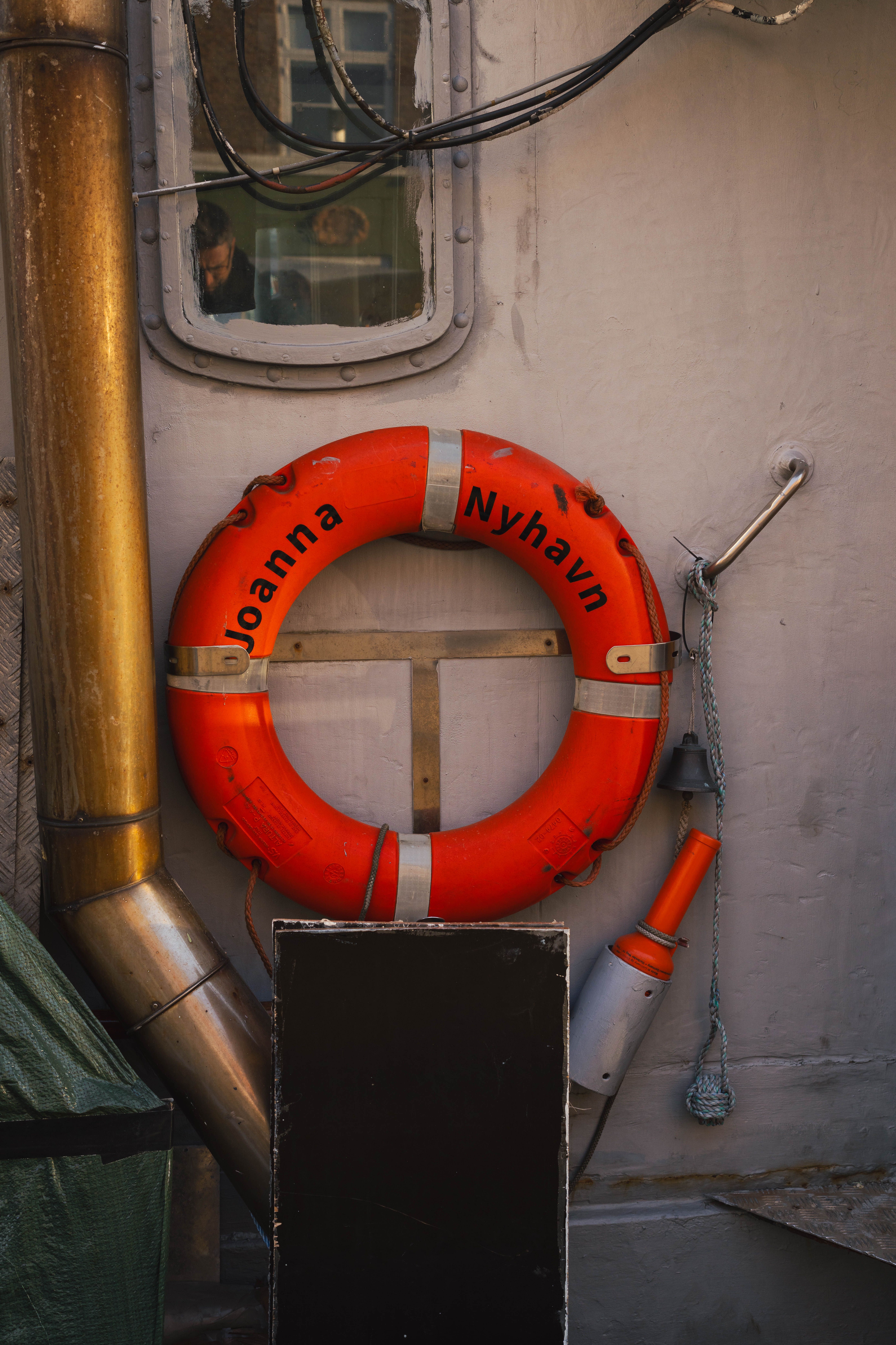 Orange lifebuoy attached to a ship at Nyhavn harbor, Copenhagen, Denmark.