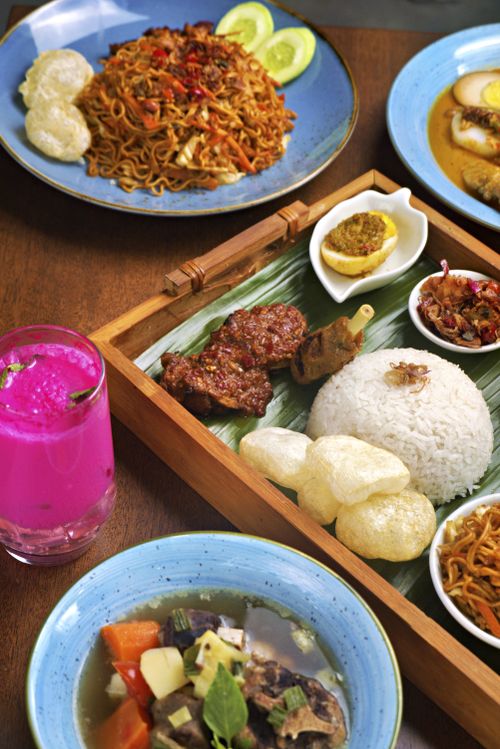 Free A colorful spread of traditional Indonesian dishes including nasi lemak, stir-fried noodles, and more. Stock Photo