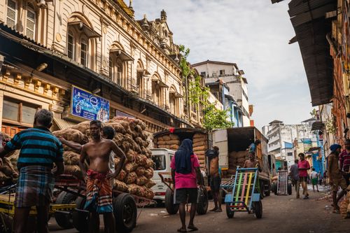 Free Dynamic scene capturing daily life in Pettah Market, Colombo, with workers loading goods. Stock Photo