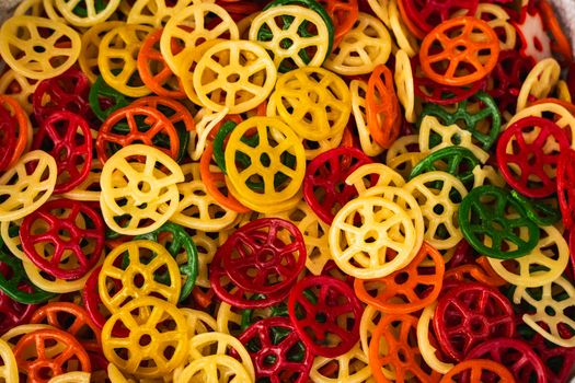 Bright and colorful wheel-shaped snacks in vibrant hues, ready to be cooked.