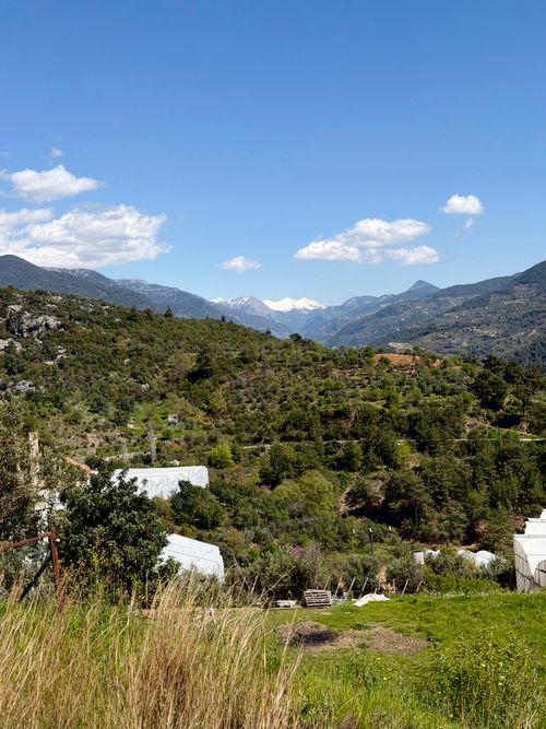 Free Beautiful view of mountains and greenery with snow-capped peaks in the distance. Stock Photo