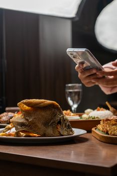 A smartphone captures delicious Indonesian fried fish served in a Jakarta restaurant.