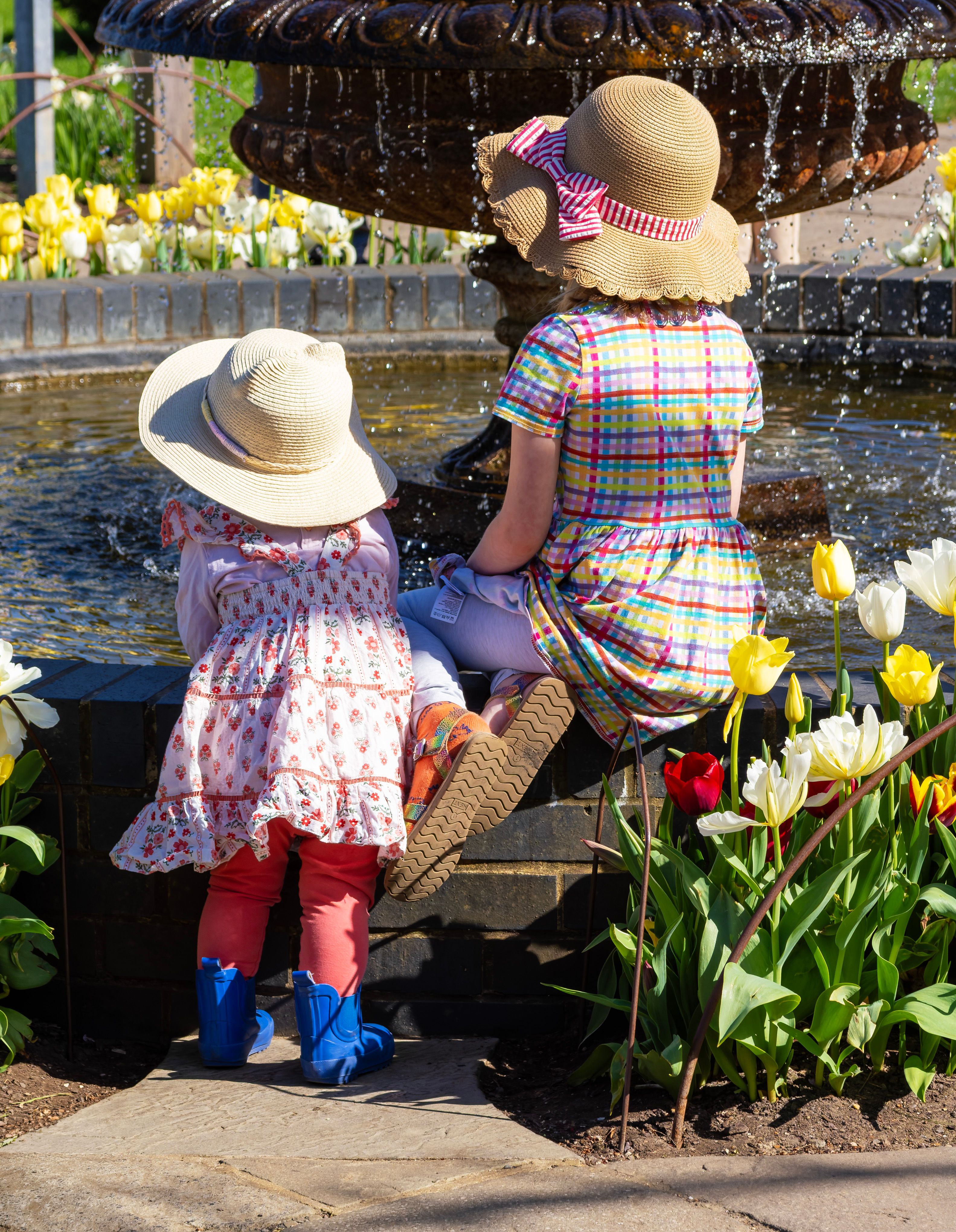 Two Girls in Sun Hats Admire Fountain in Spring · Free Stock Photo
